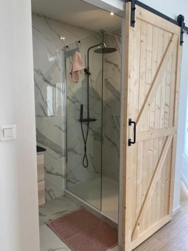 une douche avec une porte vitrée dans une salle de bain dans l'établissement Le cabanon d’Endoume, à Marseille