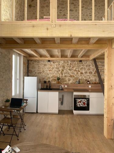 une cuisine ouverte avec des placards blancs et une table dans l'établissement Le cabanon d’Endoume, à Marseille