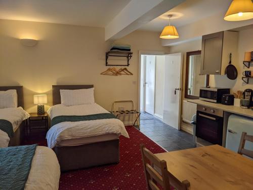 Zimmer mit 2 Betten und einer Küche mit einem Tisch in der Unterkunft The Ramblers' Rest - Princetown in Princetown