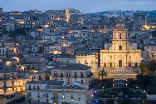 a view of a city at night with a church at Capo Scalambri in Santa Croce Camerina