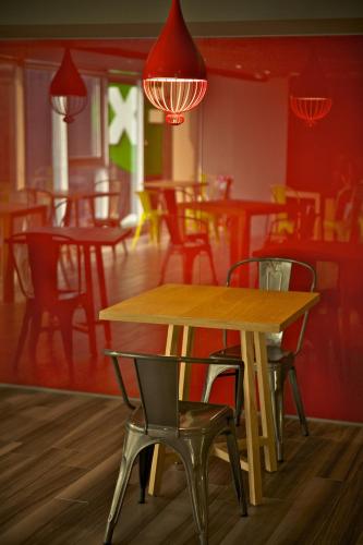 a table and chairs in a restaurant with red walls at FX INN Kaohsiung Zhonghua Road Branch in Kaohsiung