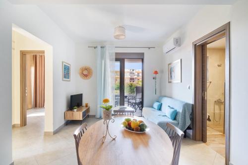 a living room with a table with a bowl of fruit on it at Lydia's Apartments in Kissamos