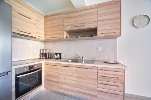 a kitchen with wooden cabinets and a sink at Lydia's Apartments in Kissamos