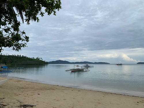 two boats sitting in the water on a beach at Bundal Riverside Room#1 in Itaytay