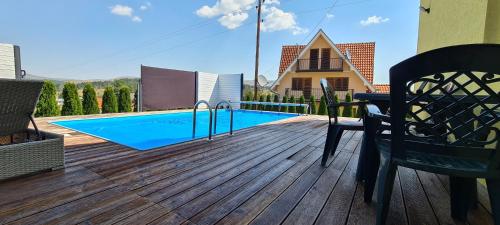 a wooden deck with a swimming pool on a house at Villa Ducic in Zlatibor