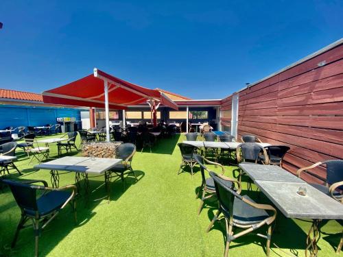 a group of tables and chairs on a patio at Hôtel Acajou in Argelès-sur-Mer