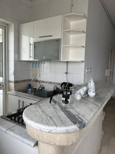 a kitchen with a marble counter top with a sink at Residence Mariem in Ariana