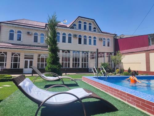 a girl is playing in a swimming pool at GUEST HOUSE "Rohat Lux" in Samarkand