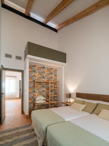 a bedroom with two beds and a mosaic wall at Apartamento para pareja, Finca Contrabando. Sanlucar del Guadiana in Sanlúcar de Guadiana