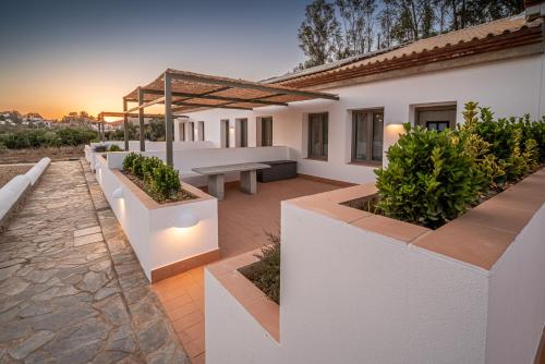 a patio of a house with a bench and plants at Apartamento para pareja, Finca Contrabando. Sanlucar del Guadiana in Sanlúcar de Guadiana