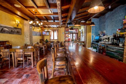 un bar con mesas de madera y sillas en un restaurante en Hostal El Guerrer, en Todolella (Tolella)