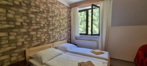 a bedroom with two beds and a brick wall at ŁOMIANKOWA DOLINA Wetlina 112 in Wetlina