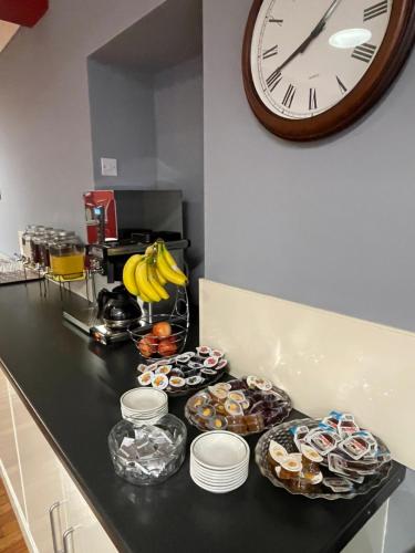 a counter with a clock and a bunch of food at Palm Court B&B in Ilfracombe
