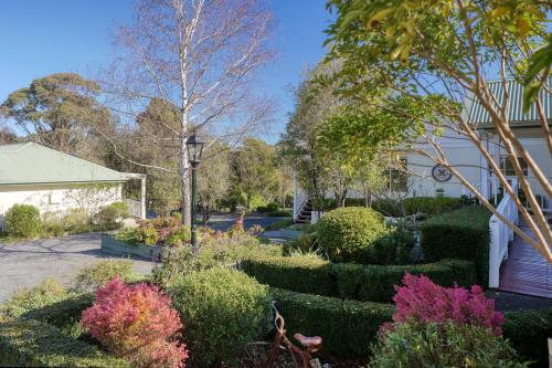 a garden in front of a house with bushes and trees at Yarra Gables in Healesville
