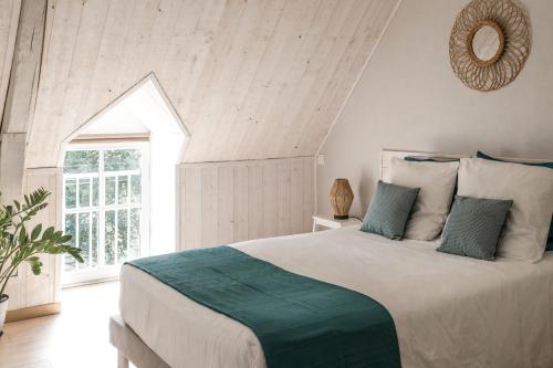 Un dormitorio con una cama grande y una ventana en Le Moulin des Forges en Sainte-Suzanne