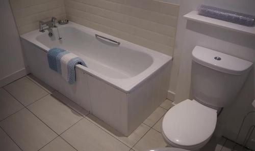 a bathroom with a white tub and a toilet at The Fiddichside Inn in Aberlour
