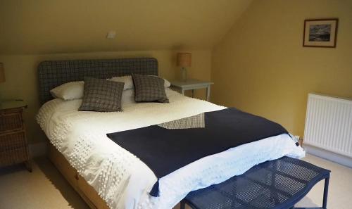 a bedroom with a large bed with white sheets and pillows at The Fiddichside Inn in Aberlour