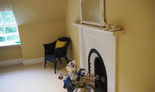 a room with a fireplace with two chairs and a mirror at The Fiddichside Inn in Aberlour