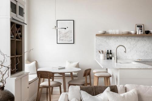 a white kitchen with a table and chairs at The Paragon, Bath in Bath