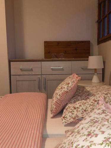 a bedroom with a dresser and two beds with pillows at Schwarzenberský panský dvůr in Čimelice