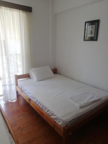 a bed sitting in a room with a window at Penelope -Πηνελόπη in Loutra Edipsou