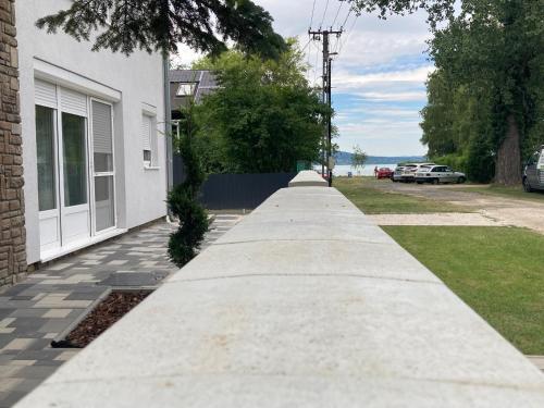 a long concrete sidewalk next to a building at Révai Apartman Fonyód in Fonyód