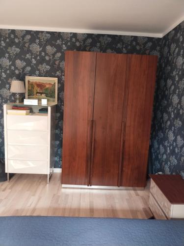 a large wooden cabinet in a room with a dresser at Apartament in Gdańsk