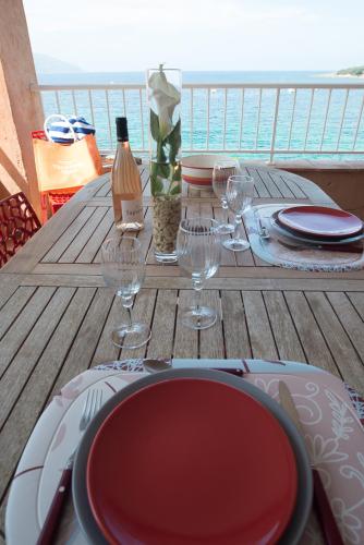 a table with plates and wine glasses on a deck at Résidence Villa Nova in Tiuccia