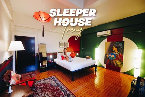 a woman sitting on a bed in a hotel room at Sleeper House in Trang
