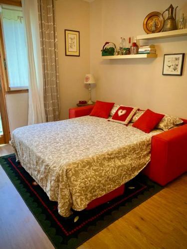 a bedroom with a large bed with red pillows at Casa GaEl in Fiumalbo