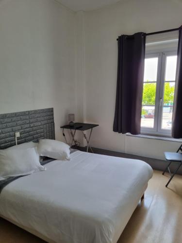 ein Schlafzimmer mit einem großen weißen Bett und einem Fenster in der Unterkunft hotel du commerce in Fauville-en-Caux