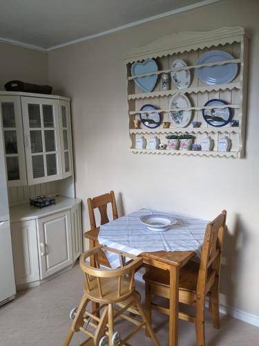 a kitchen with a table and chairs and plates on a wall at Rural apartment in Dverberg
