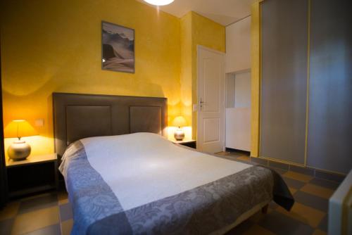 a bedroom with a large bed with yellow walls at Résidence Villa Nova in Tiuccia