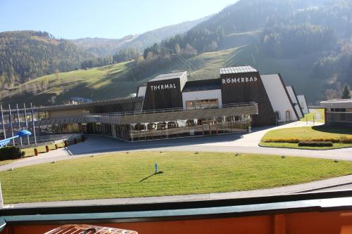 a large building with a grass field in front of it at Appartements Pulverer in Bad Kleinkirchheim