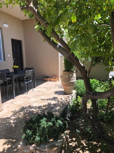 a patio with a tree and a table and chairs at Lemon Home in Heraklio Town