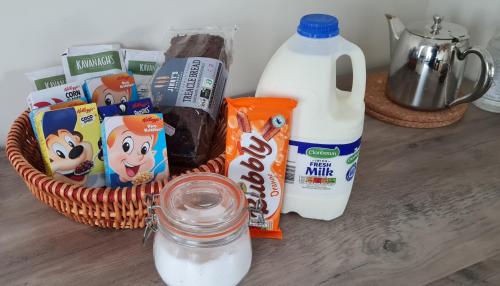 a basket of milk yogurt and other snacks on a table at Farnaught Farmhouse Apartment, Lough Rynn, Mohill in Farnaght
