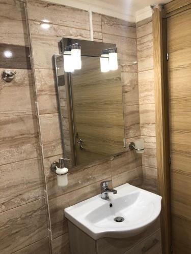a bathroom with a sink and a mirror at Lemon Home in Heraklio Town