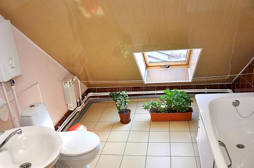 a bathroom with a toilet and a sink and a window at Slavyanskiy Club in Poltava