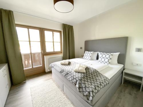 a bedroom with a large bed and a large window at Chesa Montana in Maria Alm am Steinernen Meer