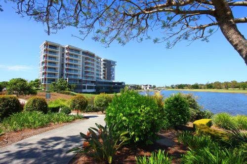a large apartment building next to a body of water at Signature Waterfront Apartments in Gold Coast