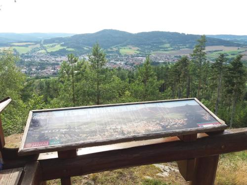 a sign sitting on top of a wooden bench at Apartmány Na Valše in Sušice