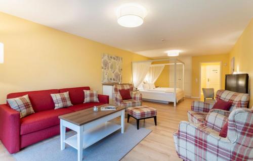 a living room with a red couch and chairs at Hotel Landhaus Ellerbrock in Sankt Peter-Ording
