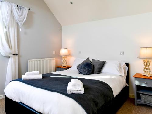 a bedroom with a large bed with towels on it at Pass the Keys Cosy Rural 2 Bed Barn conversion close to Beach in Marcross