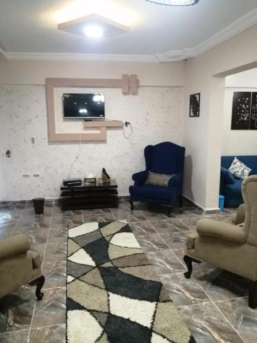 a living room with two chairs and a flat screen tv at Sea spirit in Alexandria