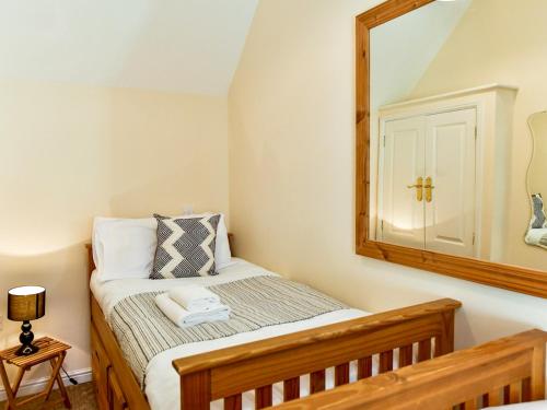 a bedroom with a bed with a mirror on the wall at Pass the Keys Cosy Rural 2 Bed Barn conversion close to Beach in Marcross