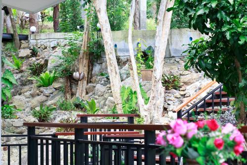 a garden with a fence and some pink flowers at 2 Bays Villa in Thong Nai Pan Yai