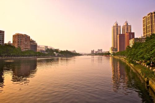 a river in the middle of a city with tall buildings at FX INN Kaohsiung Zhonghua Road Branch in Kaohsiung