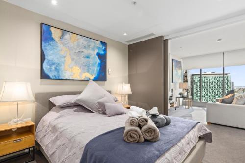 a bedroom with a bed with two stuffed animals on it at Sophisticated Designer Condo W River & City Views in Melbourne
