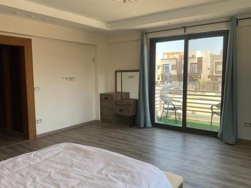 a bedroom with a bed and a large sliding glass door at Near Mall Masr - Families only - 6 october - Luxury town house in 6th Of October