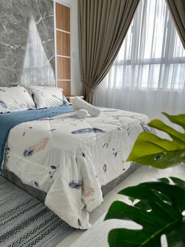 a bedroom with a bed with a comforter on it at Ani's House- 3 Bedroom Apartment at Pangsapuri Ladang Tanjung in Kuala Terengganu